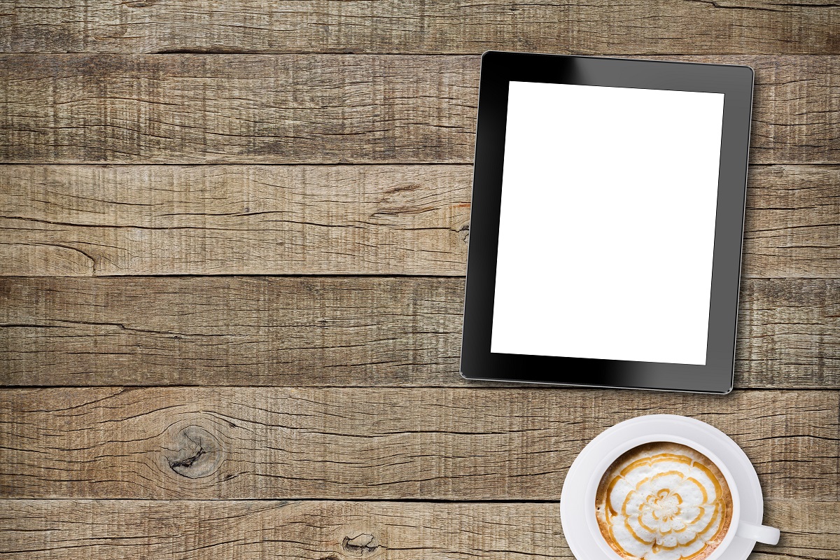 tablet white screen display and coffee on old wood background