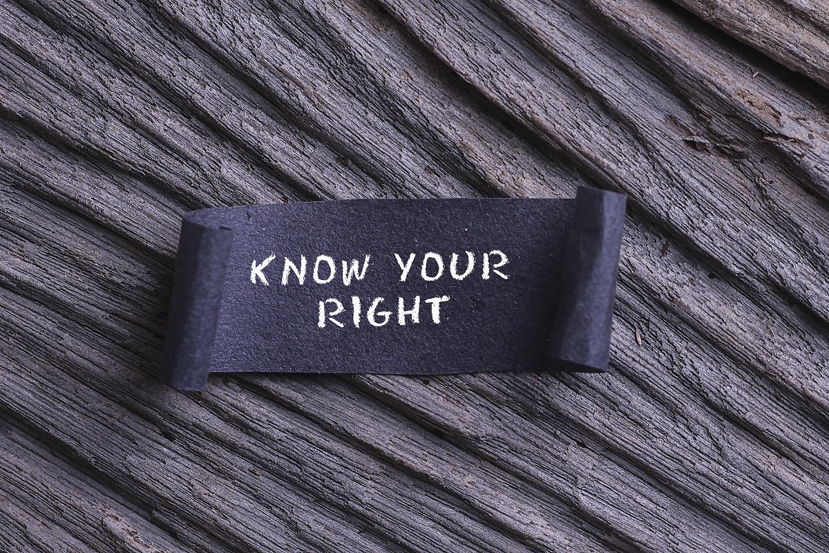 KNOW YOUR RIGHT word written on Black papper with wooden background